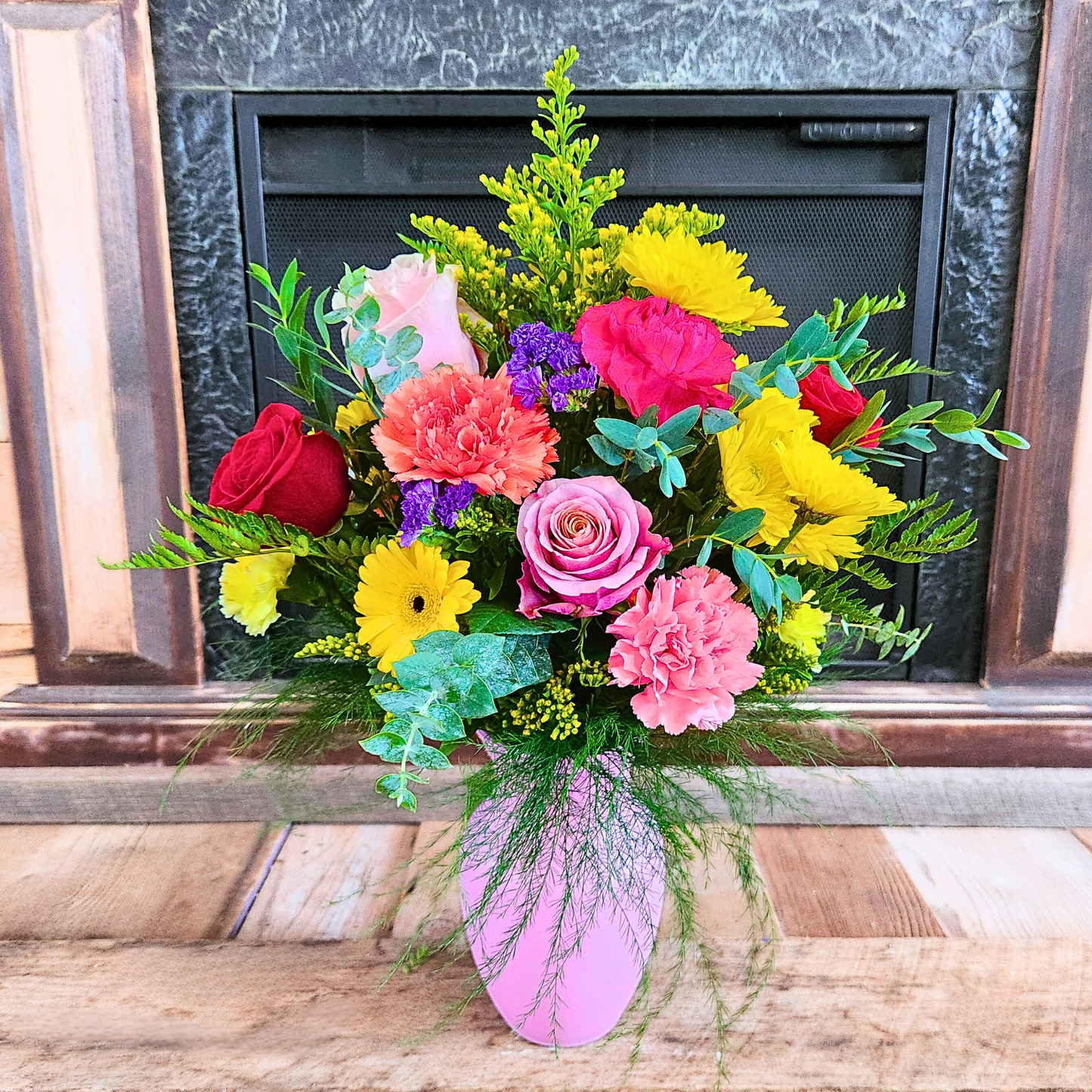Colorful bouquet of flowers in a vase against a fireplace background