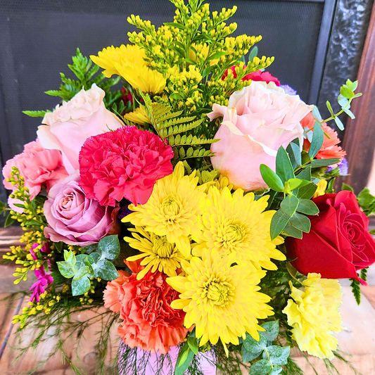 Colorful bouquet of flowers including roses and chrysanthemums with a blurred background
