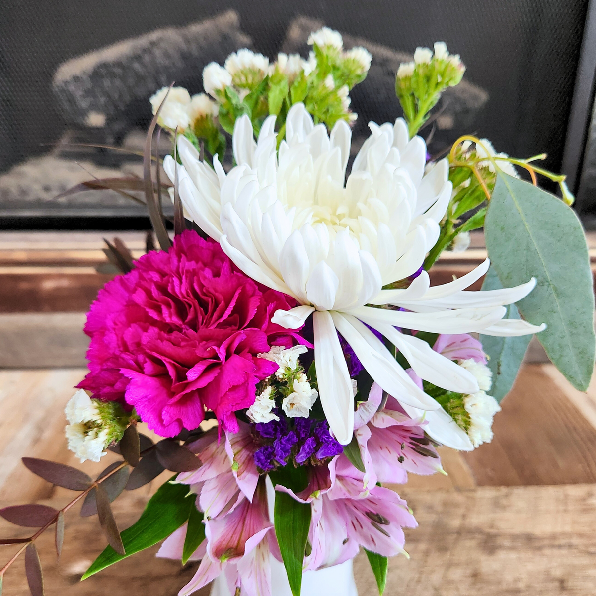Close-up of white, pink, purple, and green seasonal flowers in the Boo-tiful Blooms ghost vase arrangement from Treasured Roots Flower Shop in Hoopeston, IL.
