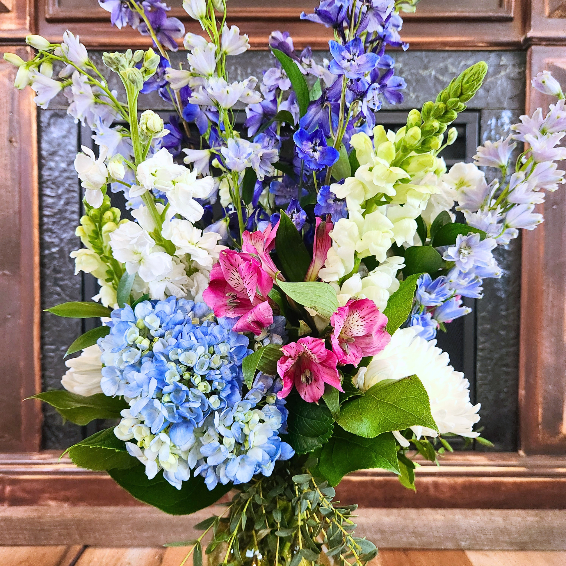 Close-up of blue hydrangea, pink alstroemeria, white blooms and blue delphinium in the Cotton Candy Skies bouquet
