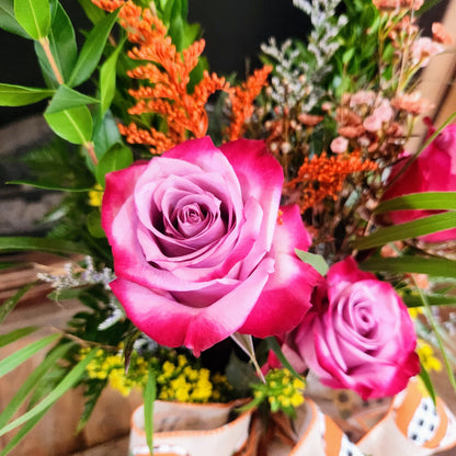 Close-up of a lavender-centered rose fading to deep pink outer petals, one of the possible rose colors for the Enchanted Harvest Bouquet from Treasured Roots Flower Shop in Hoopeston, IL.