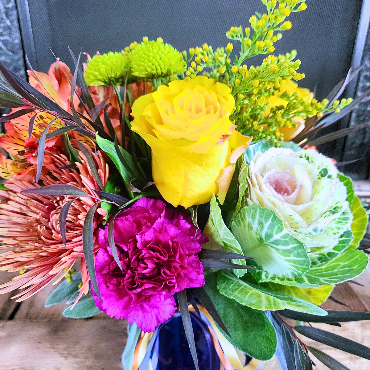 Close-up of ornamental kale, roses, mums, and colorful seasonal flowers in the Kale Yeah, It’s Fall bouquet from Treasured Roots Flower Shop in Hoopeston, IL.