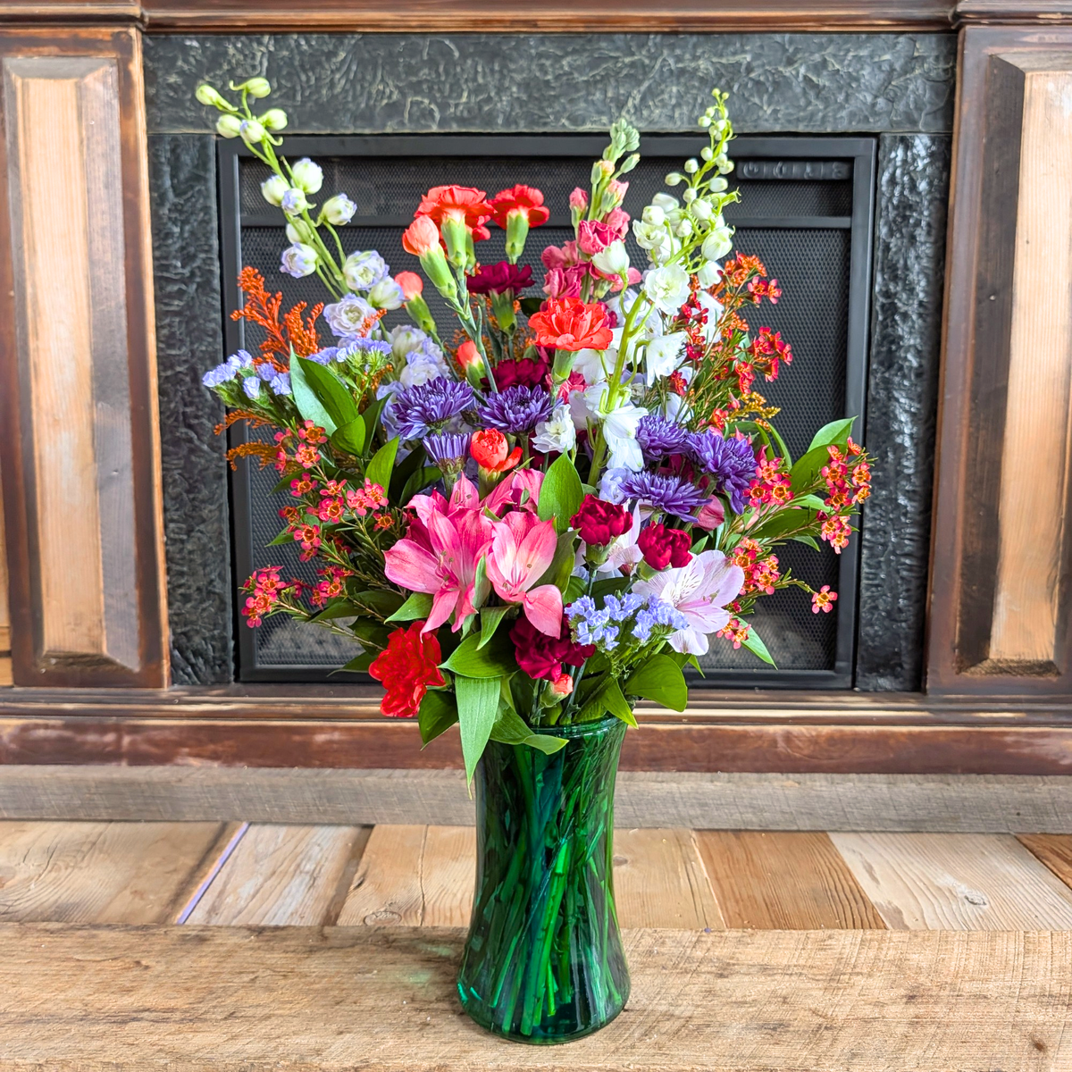 October Skies tall fall flower bouquet with purple, pink, blue, white, and warm autumn blooms in a glass vase from Treasured Roots Flower Shop in Hoopeston, IL.