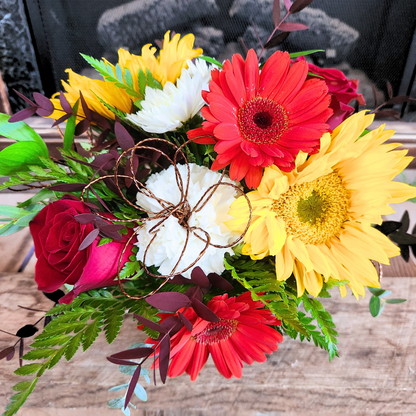 Close-up of Petal to the Metal showing red, yellow, and white fall flowers with mixed eucalyptus and greenery from Treasured Roots Flower Shop in Hoopeston, IL.