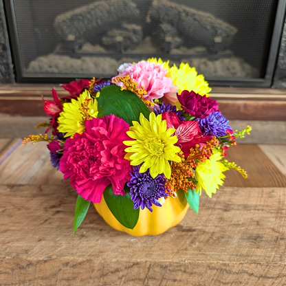 Pick of the Patch fall flower arrangement with yellow, red, burgundy, pink, and purple blooms in an orange pumpkin container from Treasured Roots Flower Shop in Hoopeston, IL.