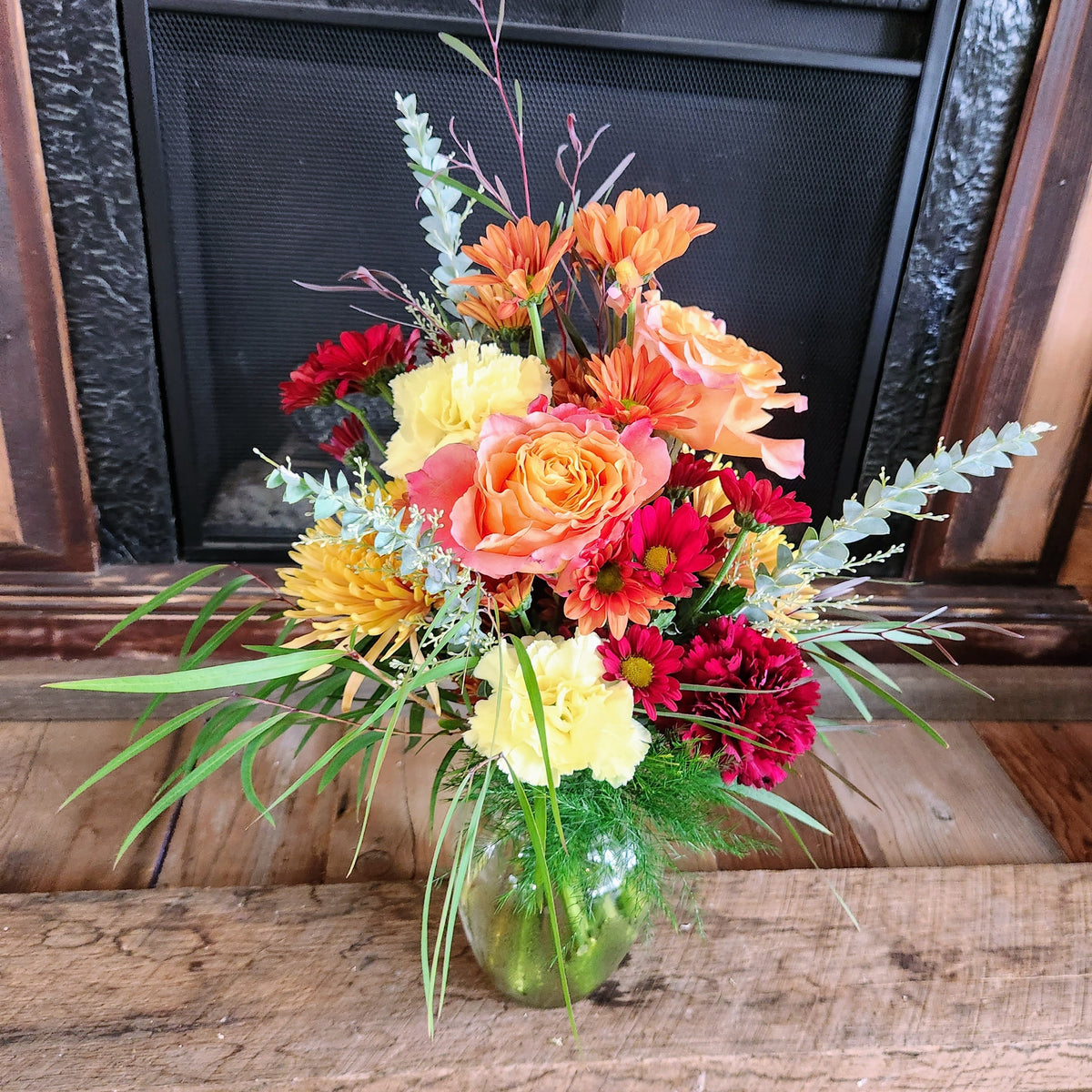 Practical Magic fall bouquet with peach, orange, yellow, red, and cream seasonal flowers accented with light airy greenery from Treasured Roots Flower Shop in Hoopeston, IL.